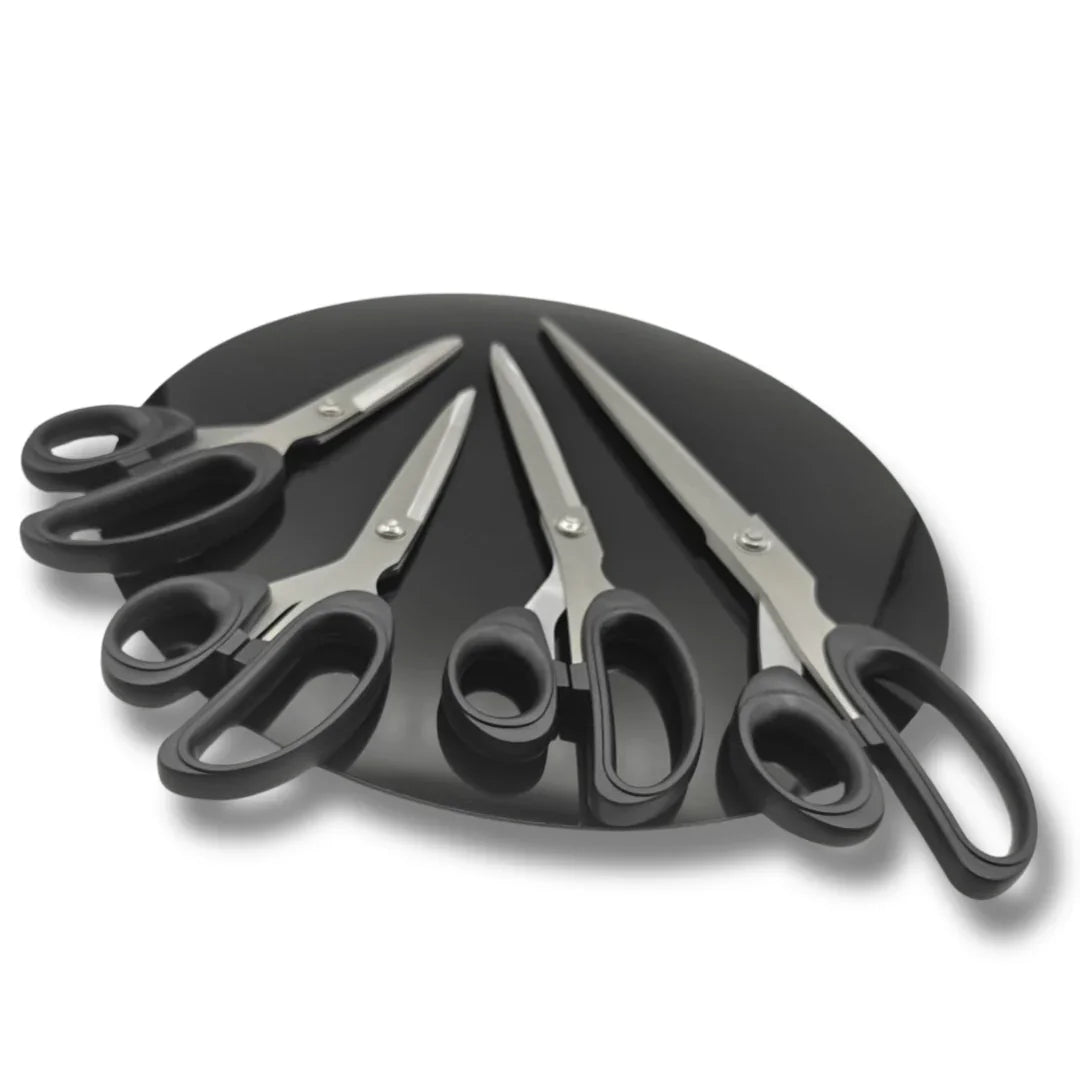 Quatre ciseaux de couture professionnels à manches noirs sur fond noir, ACCESSOIRES LEDUC.